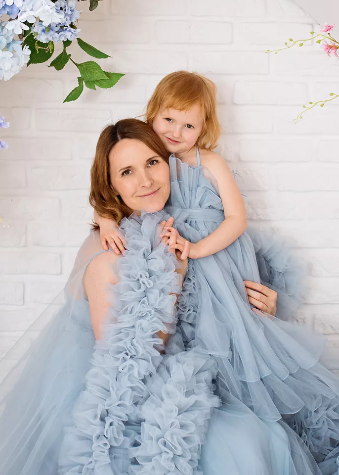 Family session among flowers — mother and daughter in tulle dresses in a studio in Warsaw