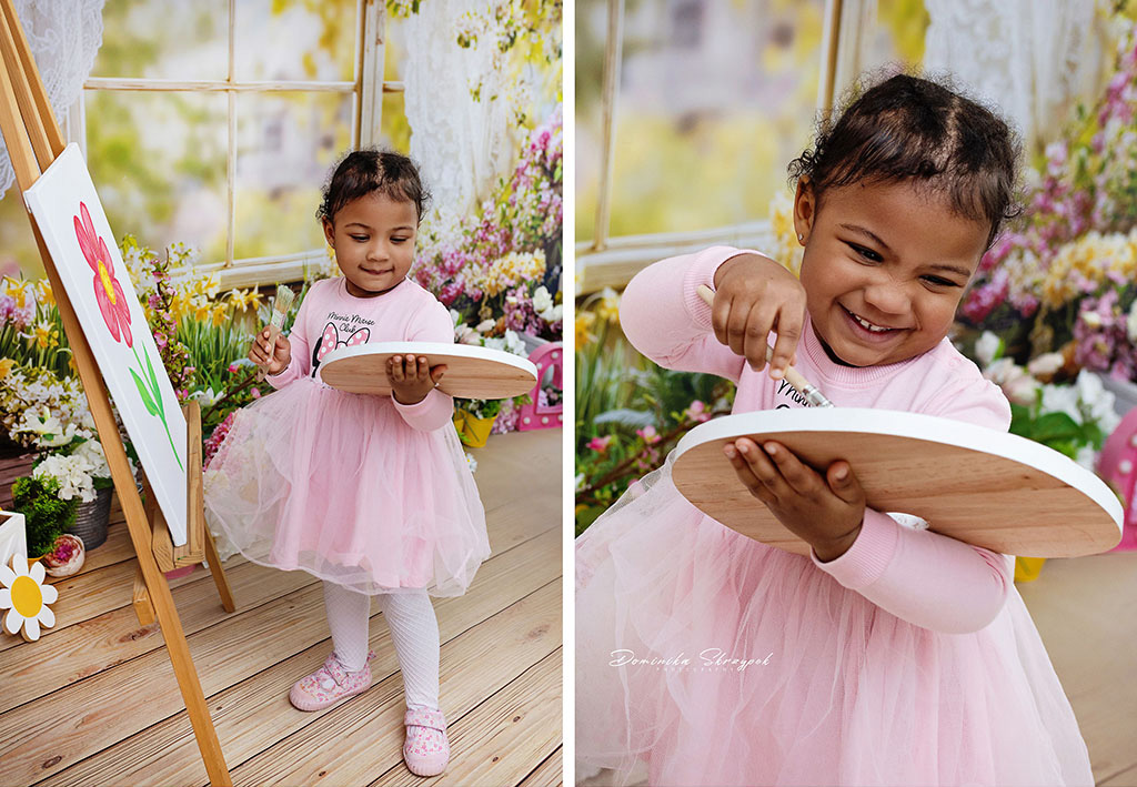 Little girl painting with a brush during a photo session at a nursery in Warsaw
