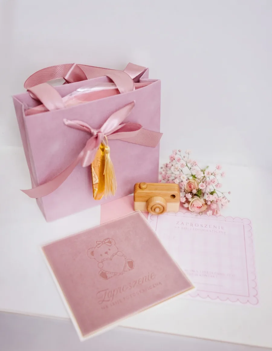 Pink velour photo session gift voucher with a bouquet of roses and a wooden camera