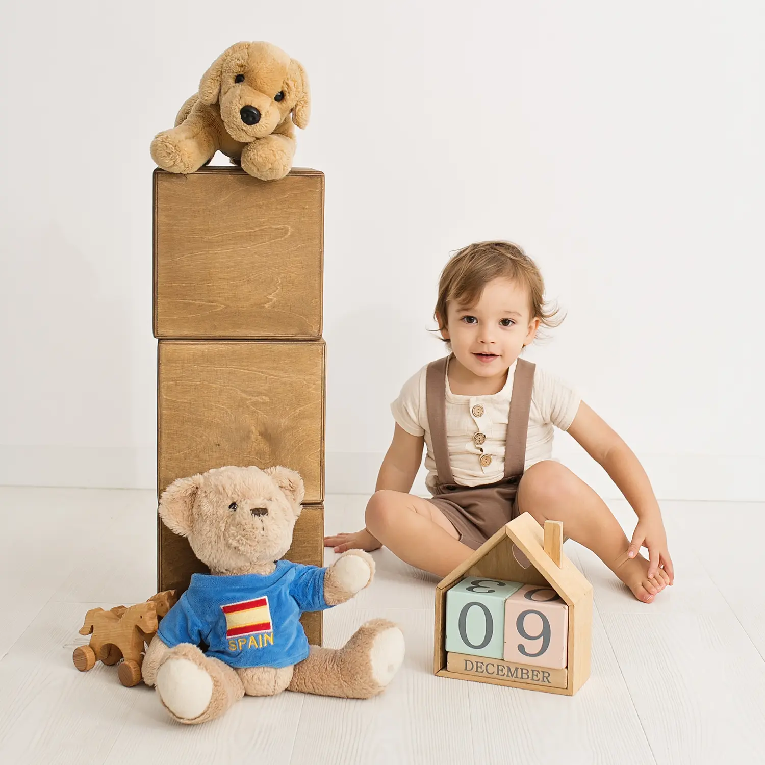 Toddler with wooden blocks and soft toys at a birthday photo session in a Warsaw studio